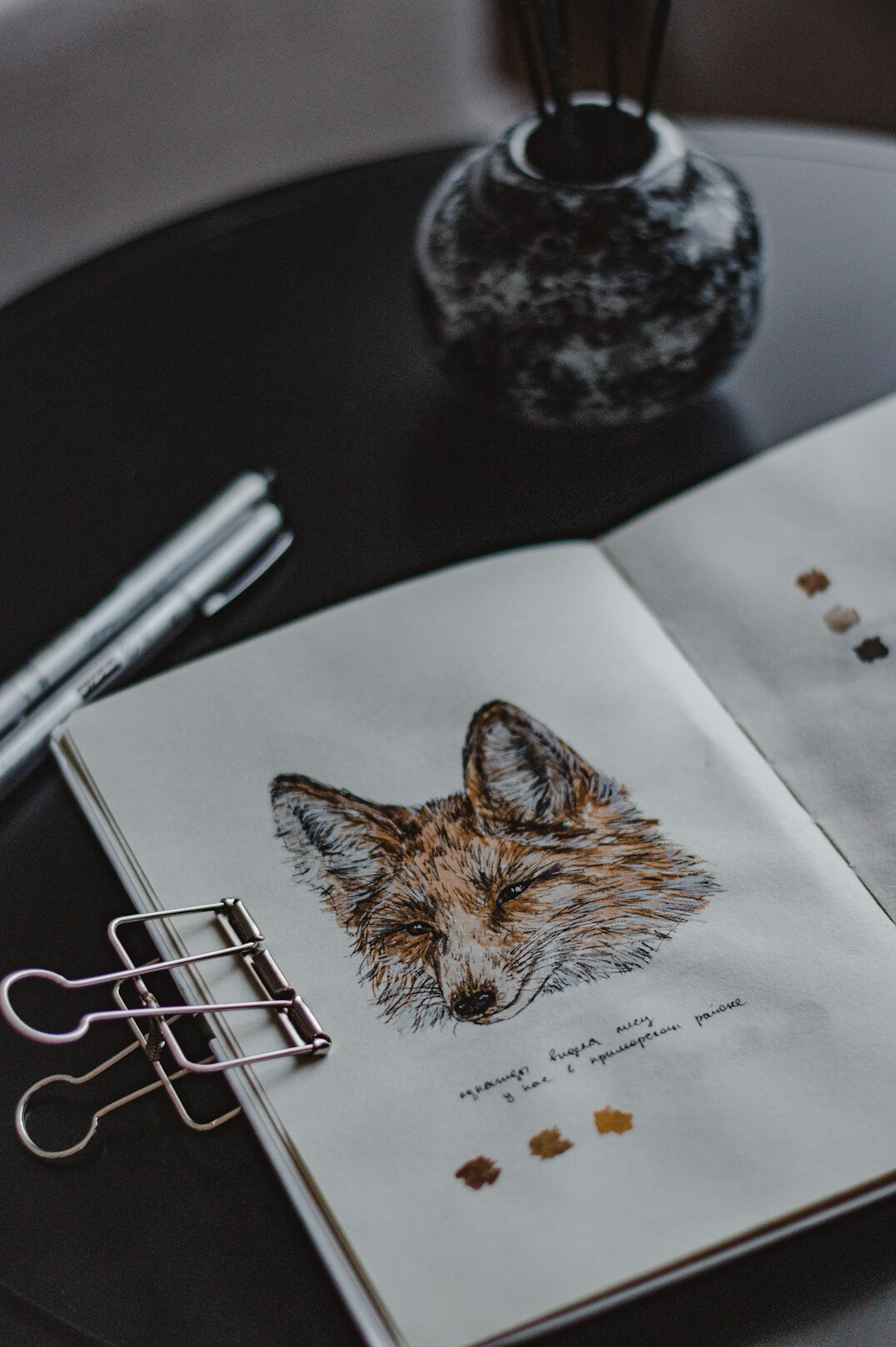 Open journal with pencil drawings and pens