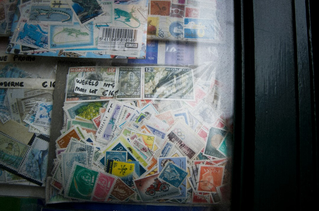 Vintage postage stamps and magnifying glass on a wooden desk